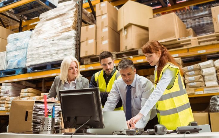 Warehouse,Managers,And,Worker,Working,On,Laptop,In,A,Large